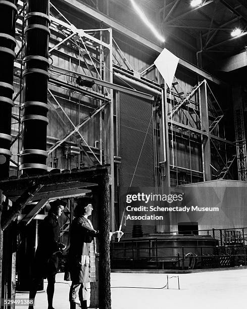 Replica of Benjamin Franklin and his 22-year-old son inside General Electric's High Voltage Engineering Laboratory. This kite and lightning display...