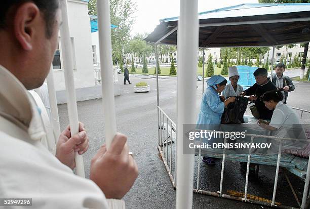 Nurses and security check bags of food given by relatives of those who lie injured in hospital following clashes between government forces and local...