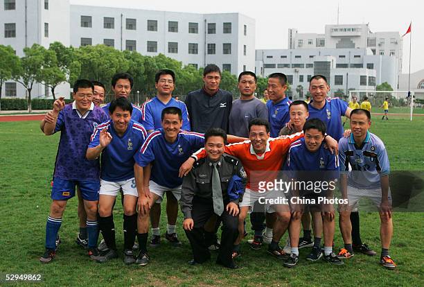 Chinese football star Fan Zhiyi poses for a picture with inmates and warden at Qingpu Prison on May 18, 2005 in Shanghai, China. Fan visited the...