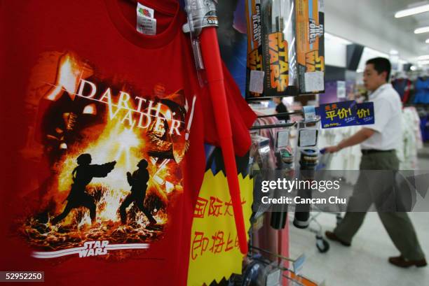 Shirts and other souvenirs of the movie "Star Wars: Episode III - Revenge of the Sith" are displayed for sale at a newly opened Wal-Mart supermarket...