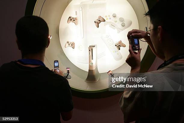 Attendees photograph an XBox 360 game console displayed in the Microsoft Corp. Exhibit area at the 11th annual Electronic Entertainment Expo on May...