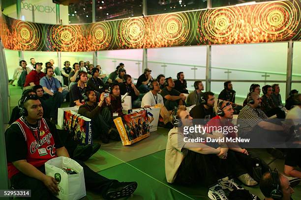 Attendees watch an XBox 360 game console promotional presentation in the Microsoft Corp. Exhibit area at the 11th annual Electronic Entertainment...