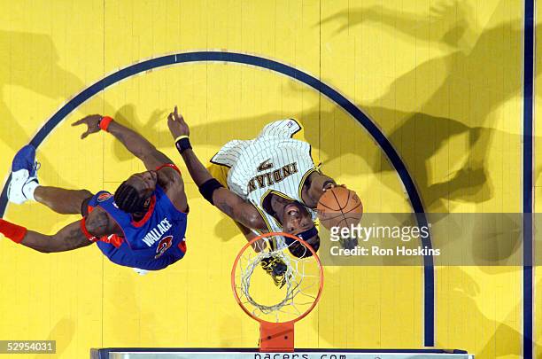Jermaine O'Neal of the Indiana Pacers lays the ball up over Ben Wallace of the Detroit Pistons in Game six of the Eastern Conference Semifinals...