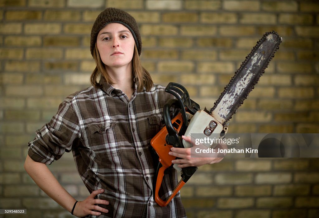 Young adult with a chainsaw portrait