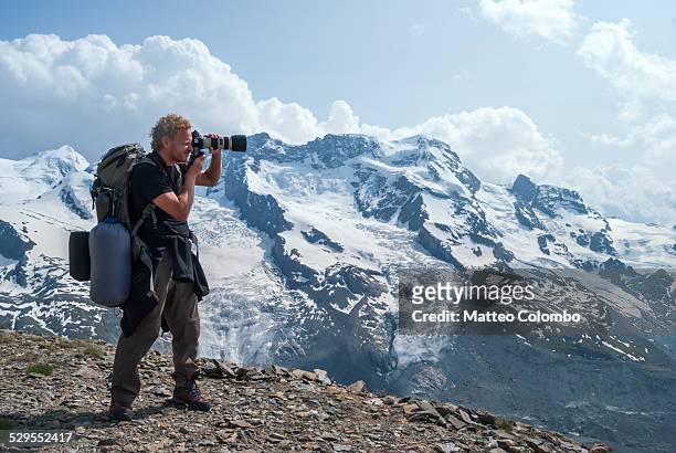 hiker on the swiss alps in summer taking a photo - telephoto lens stock pictures, royalty-free photos & images