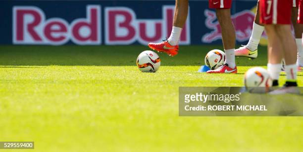 Football players warm up in front of a "Red Bull" advertising banner on display at the stadium prior to the German second division Bundesliga...