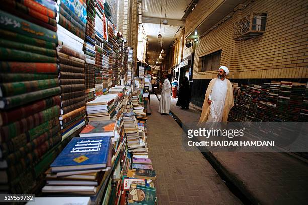 An Iraqi Shiite scholar who teaches at a school for clerics, known in Arabic as Haouza, walks past book stalls in the holy city of Najaf, 160 kms...