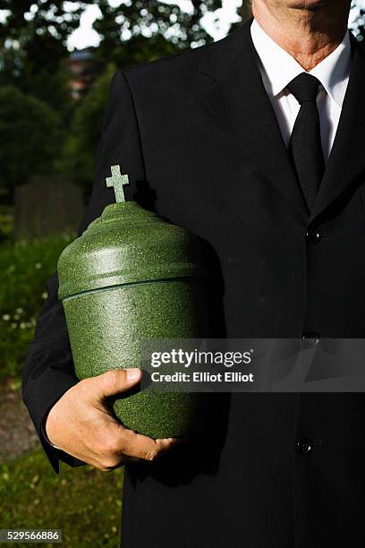 mature man holding urn - urn stock pictures, royalty-free photos & images