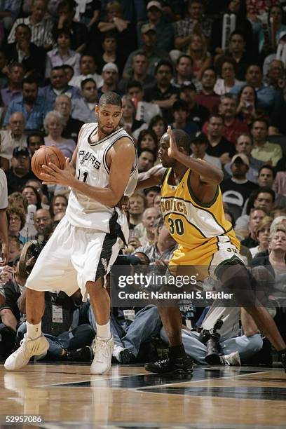 Tim Duncan of the San Antonio Spurs backs in against Reggie Evans of the Seattle SuperSonics in Game two of the Western Conference Semifinals of the...