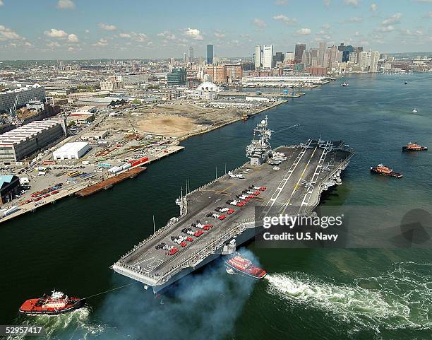 In this handout from the U.S. Navy, the conventionally powered aircraft carrier USS John F. Kennedy makes her way into historic Boston Harbor as crew...