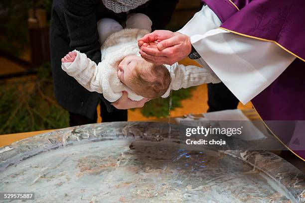 priest is baptizing little baby girl in a church - catholicism bildbanksfoton och bilder