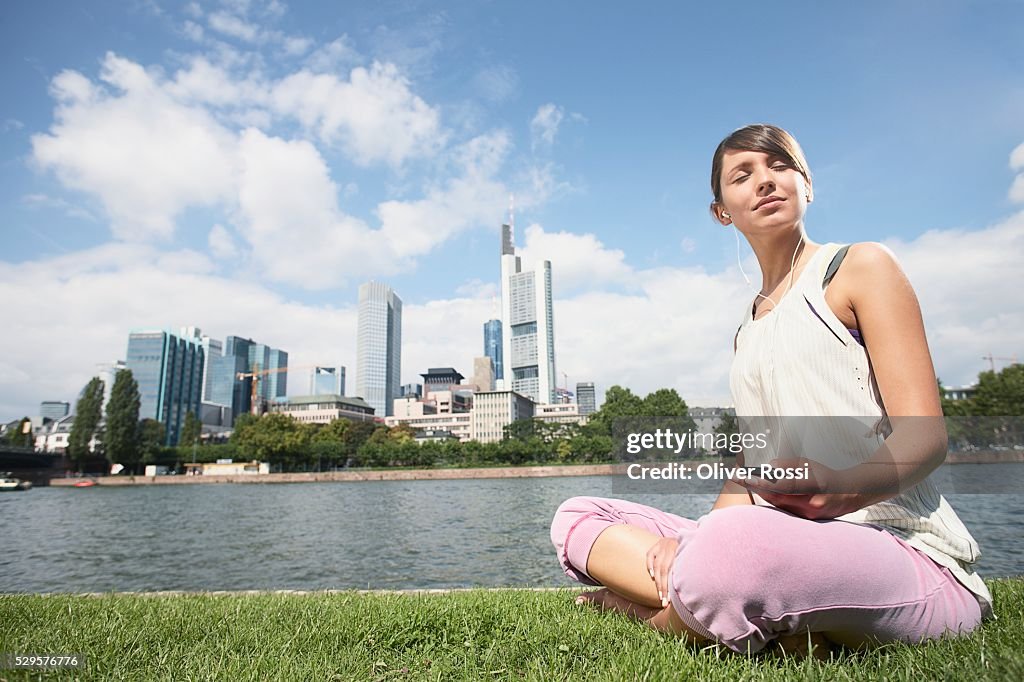 Woman Sitting by Riverbank