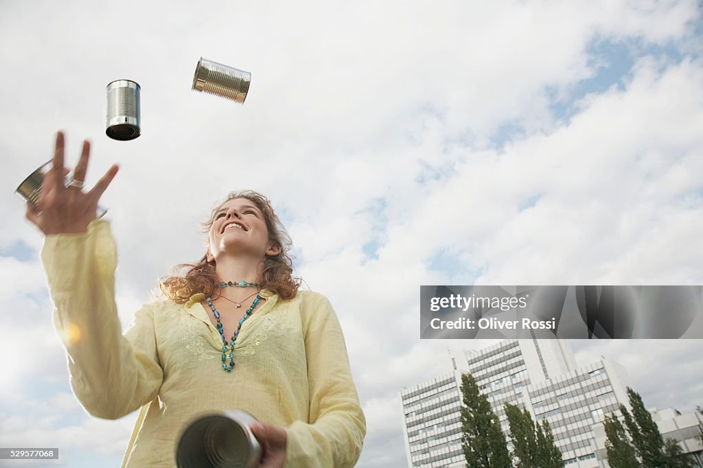 Woman Juggling Tin Cans