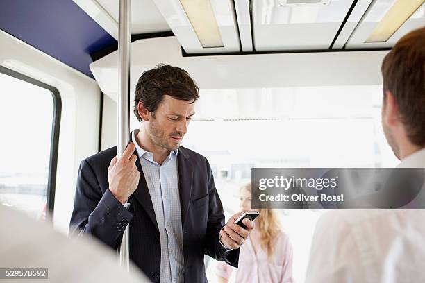 business man text messaging on bus - public transport stock-fotos und bilder