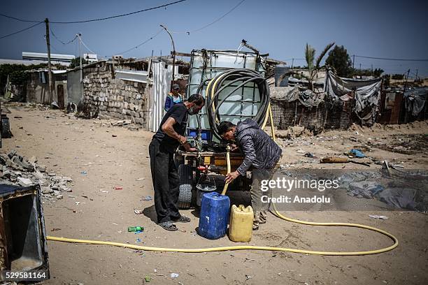 Man fills a bucket with water brought by a water tank carriage as Palestinians face a water crisis in Gaza City, Gaza on May 9, 2016. Palestinians...