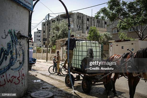 Man fills a bucket with water brought by a water tank carriage as Palestinians face a water crisis in Gaza City, Gaza on May 9, 2016. Palestinians...