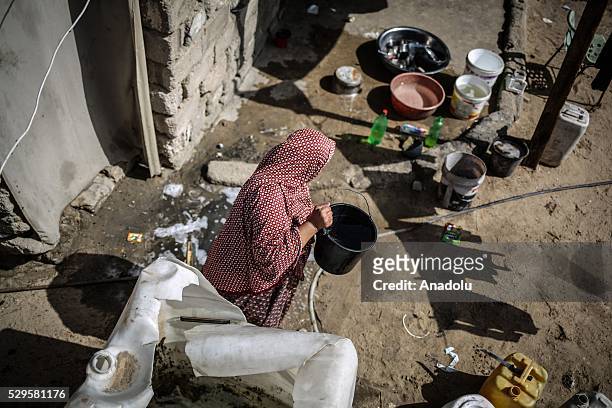 Woman fills a bucket with water brought by a water tank as Palestinians face a water crisis in Gaza City, Gaza on May 9, 2016. Palestinians use most...