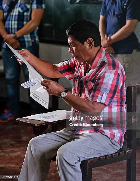 Rodrigo Duterte, Mayor of Davao and presidential candidate, looks at a ballot paper at a polling station during the presidential election in Davao,...