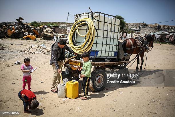 Man fills a bucket with water brought by a water tank carriage as Palestinians face a water crisis in Gaza City, Gaza on May 9, 2016. Palestinians...
