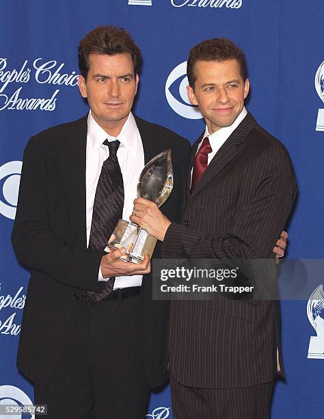 Charlie Sheen and Jon Cryer hold their award in the press room at the 30th Annual People's Choice Awards.