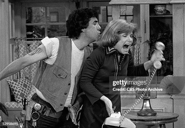 Schneider sneaks up behind Ann as she attempts to make a phone call in a scene from the sitcom 'One Day at a Time,' 1975.