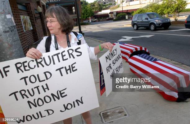 Susan Keith holds up signs in protest of the Iraq War and Army recruiting practices May 20, 2005 in Atlanta, Georgia. The Army Recruiting Command has...