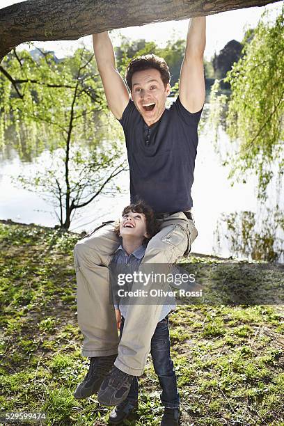 father and son (7-9) playing in park - rolwisseling stockfoto's en -beelden