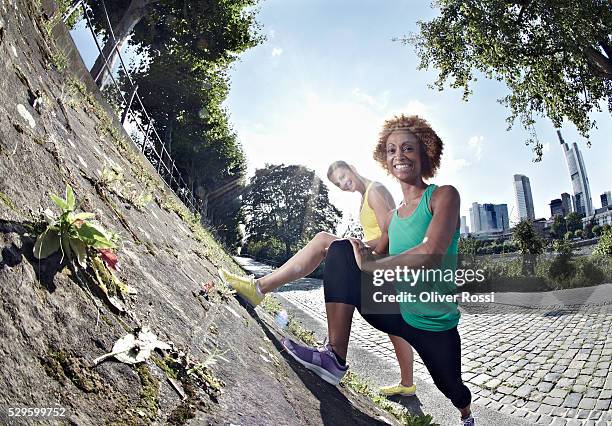 two women stretching in park - fish eye lens people stock pictures, royalty-free photos & images