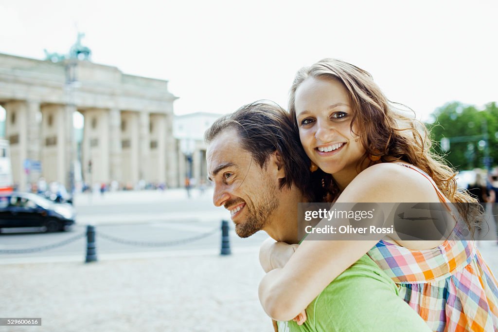 Man giving woman piggy back ride in city