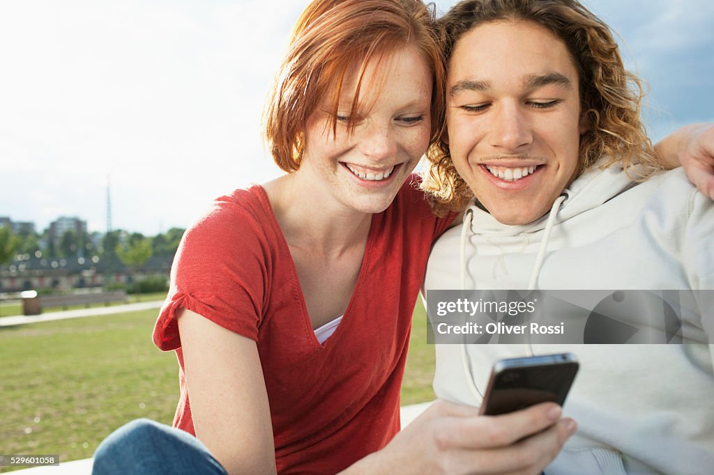Teen (16-17) couple reading text messages