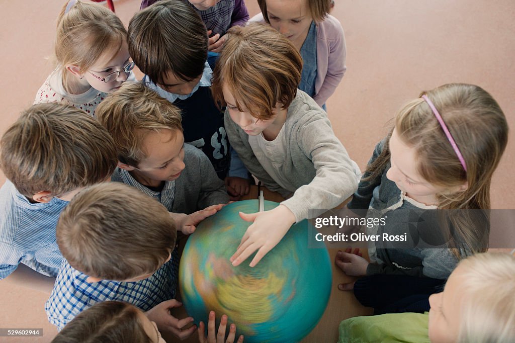 Group of school children (6-7) looking at globe
