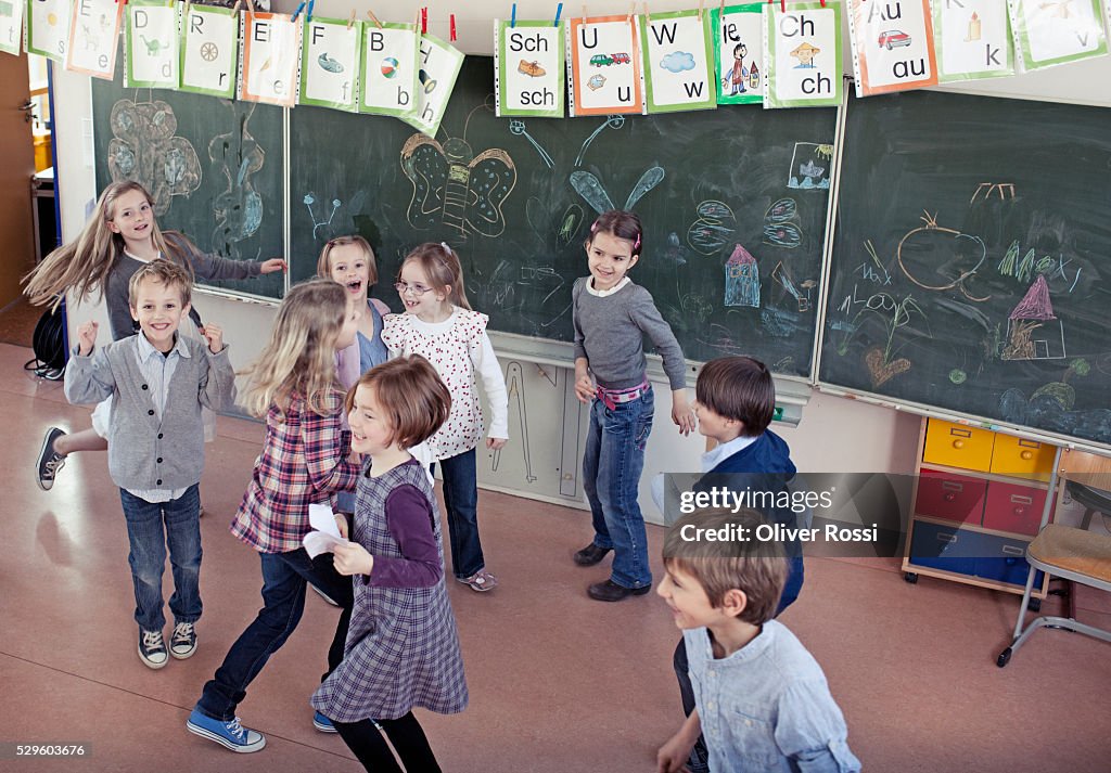 Group of schoolchildren (6-7) playing in classroom