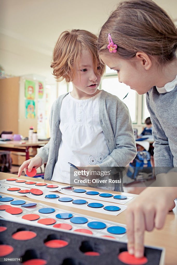 Boy (6-7) and girl (6-7) playing educational game