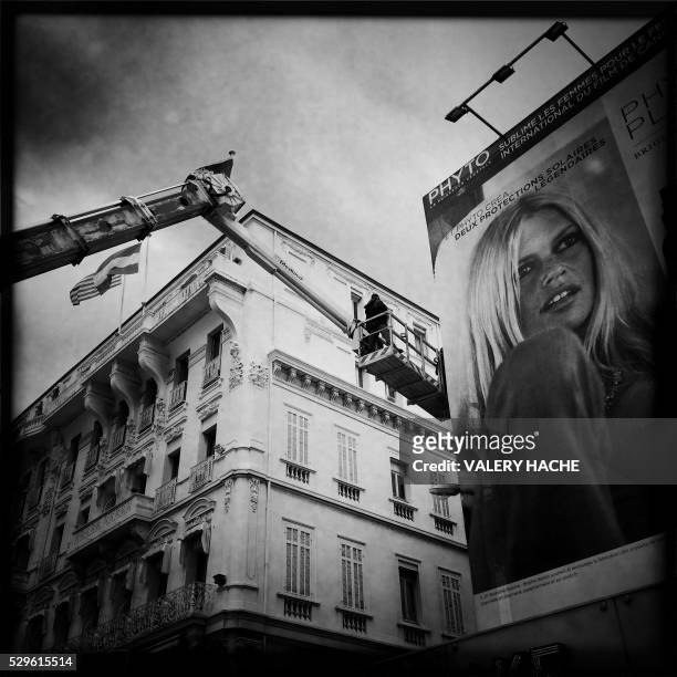 Photo taken with a mobile phone shows workers setting up a giant poster of the young French actress Brigitte Bardot before the 69th Cannes' film...