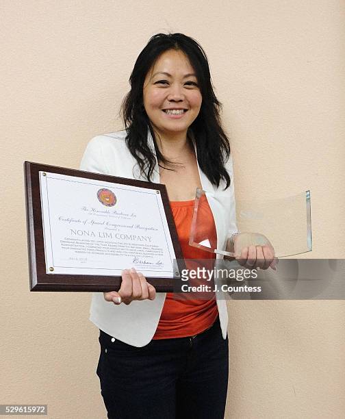 Entrepreneur Nona Lim holds her awards she received from the SBA during the Healthy Business, Healthy Communities Reception on the final day of...