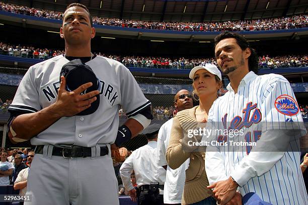Alex Rodriguez of the New York Yankees stands for the National Anthem with Jennifer Lopez and husband Mark Anthony before the game against the New...