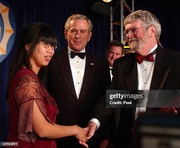 President George W. Bush and Nhanny Heil congratulate Chick Herrity as he receives the White House News Photographers Association "Lifetime...
