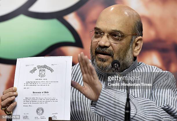 President Amit Shah shows the Bachelors Degree of Prime Minister Narendra Modi during a press conference at BJP HQ on May 9, 2016 in New Delhi,...