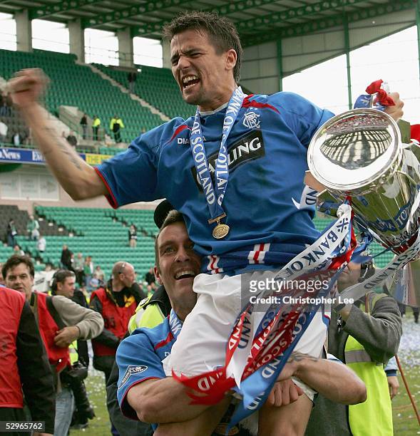 Nacho Novo of Rangers is lifted into the air by his captain Fernando Ricksen as they celebrate with the Scottish Premier League trophy during the...