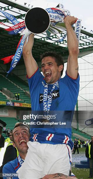 Nacho Novo of Rangers is lifted into the air by his captain Fernando Ricksen as they celebrate with the Scottish Premier League trophy during the...