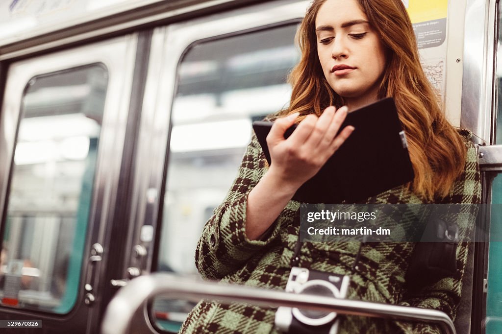 Woman reading e-book in the subway