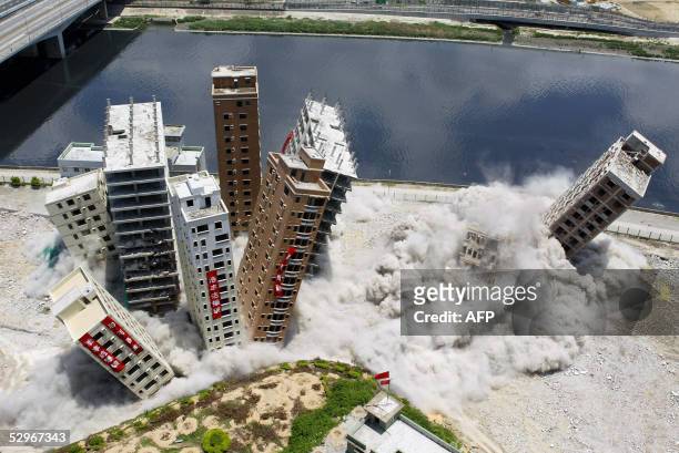 Buildings topple from a controlled-explosion set off during their demolition, dubbed "China's number one blast" by the Chinese media, at the...