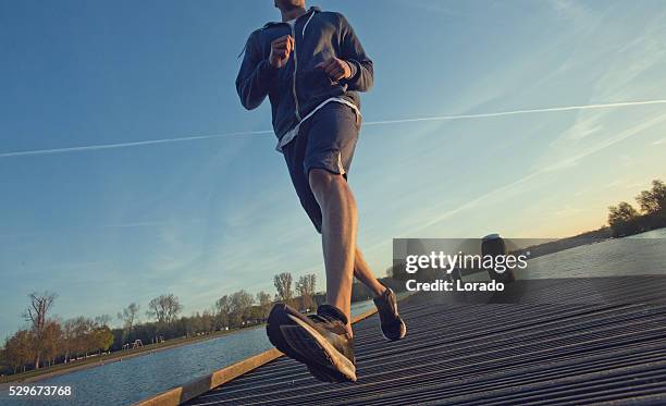 male jogging at dawn on a lakeside pier - early bird stock pictures, royalty-free photos & images