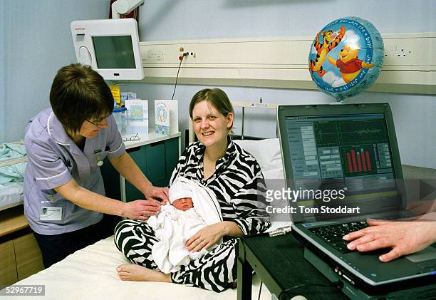 Laura Shanley with her day old son, Jack Shanley, in the Orchard Maternity Ward at Brentford Hospital being given his hearing test before being...