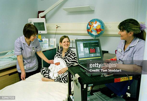 Laura Shanley with her day old son, Jack Shanley, in the Orchard Maternity Ward at Brentford Hospital being given his hearing test before being...