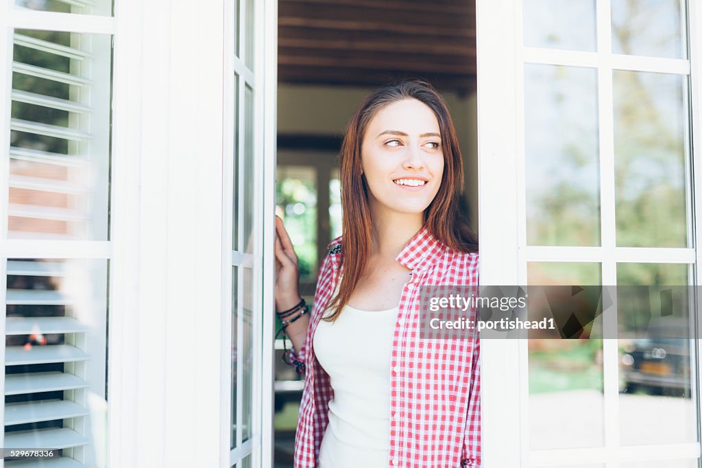 Young woman looking through the window