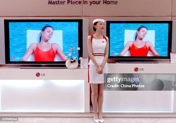 Promotion girl shows LG's Televisions at the China International High-tech exhibition on May 23, 2005 in Beijing, China. China, the world's...