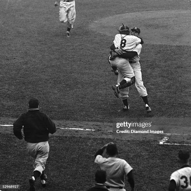 Pitcher Don Larsen , of the New York Yankees, wraps his arms around catcher Yogi Berra after the final pitch of Game 5 of the 1956 World Series...
