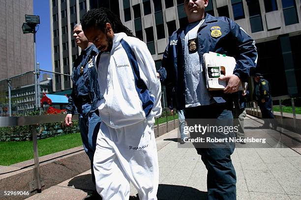 Federal Marshals assigned to Immigration and Customs Enforcement escort members of a group of eight arrested for marijuana distribution May 10, 2005...