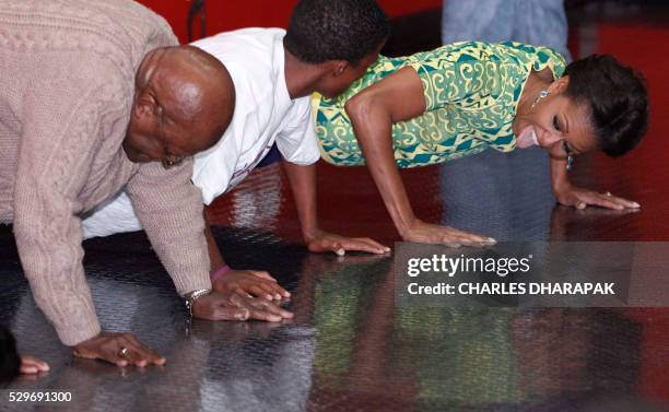 First Lady Michelle Obama does push ups with Archbishop Desmond Tutu as they participates in youth activities raising awareness for HIV prevention at...